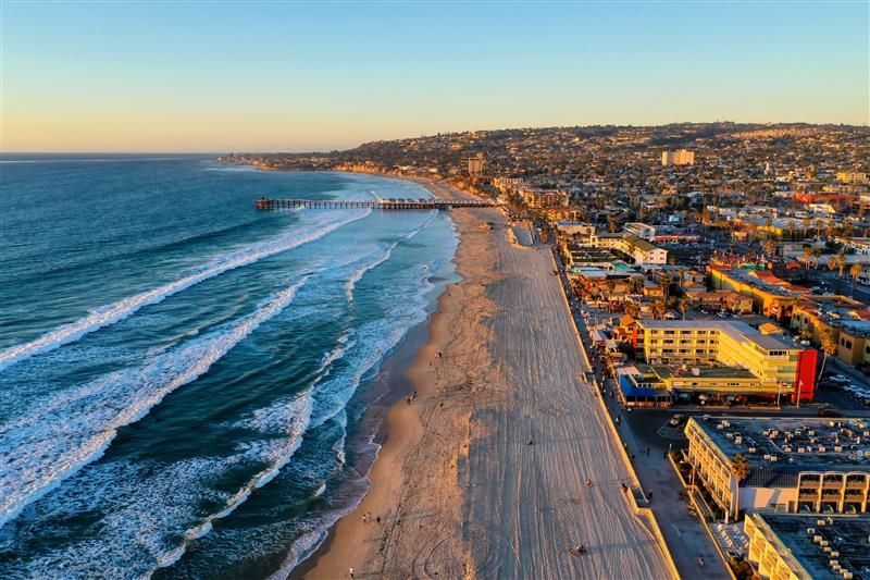 a beach with buildings and waves