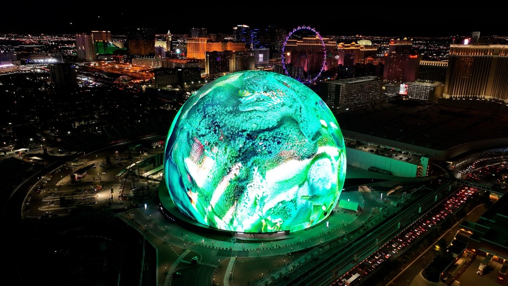 A striking aerial view of the glowing sphere at night during the Arenas Operators & Developers World Summit 2026.