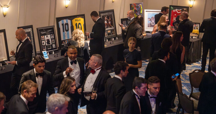 Guests admire sports memorabilia at the PAY360 Awards event.