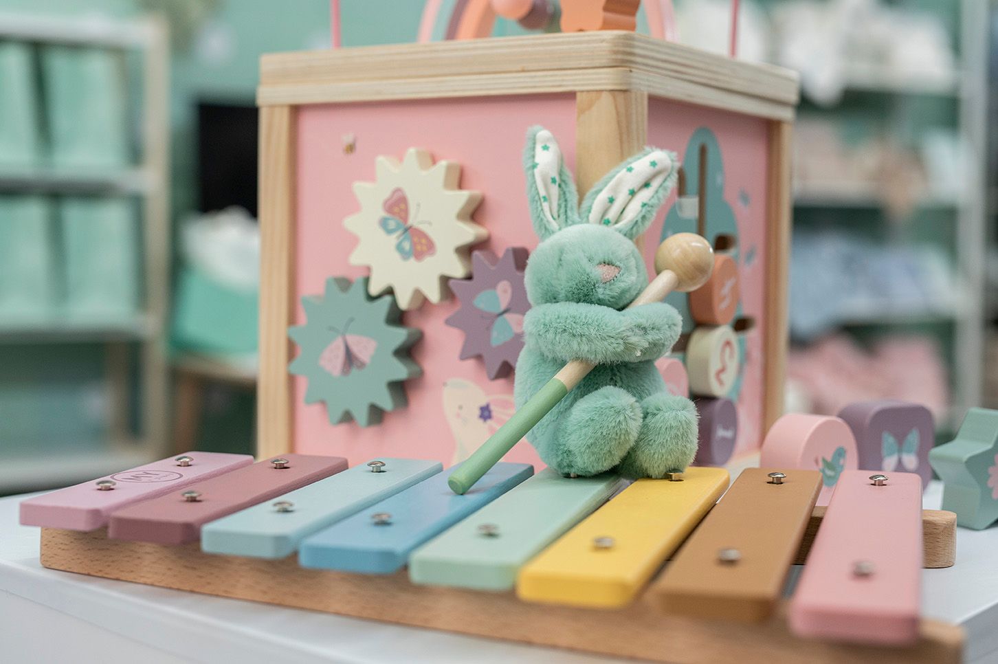 A toy bunny sitting on a xylophone.